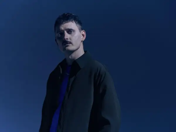 Dawid Podsiadło w granatowej stylizacji, promujący swoje nowe płyty.